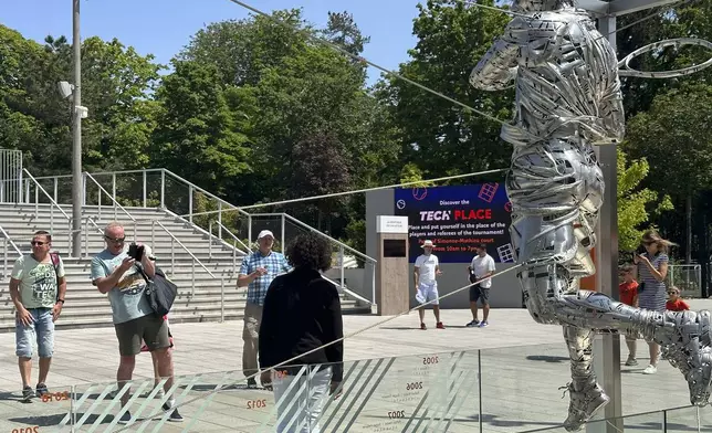 FILE - Tennis fans take images of Spain's Rafael Nadal's statue during their first round match of the French Open tennis tournament at the Roland Garros stadium in Paris, May 29, 2023. (AP Photo/Howard Fendrich, File)