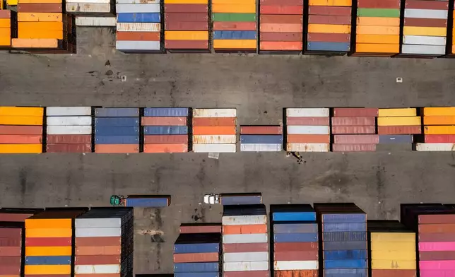 Trucks drive past shipping containers at the San Juan port, Puerto Rico, Thursday, May 8, 2025. (AP Photo/Alejandro Granadillo)