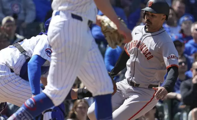 San Francisco Giants' LaMonte Wade Jr., right, is tagged out by Chicago Cubs catcher Carson Kelly during the fourth inning of a baseball game in Chicago, Wednesday, May 7, 2025. (AP Photo/Nam Y. Huh)