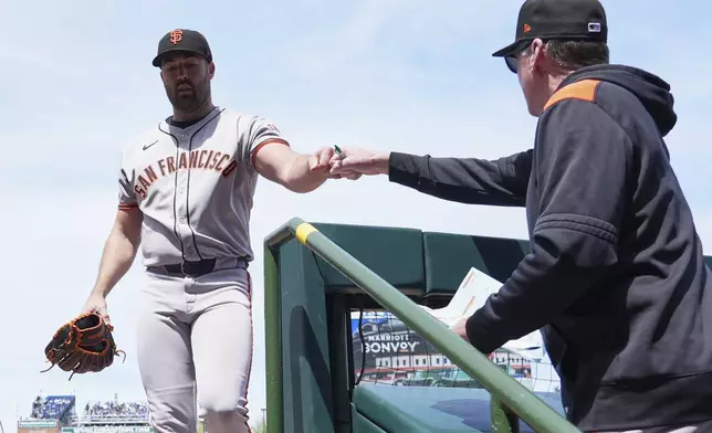 San Francisco Giants starting pitcher Robbie Ray, left, gets a fist pump from manager Bob Melvin after the first inning of a baseball game in Chicago, Wednesday, May 7, 2025. (AP Photo/Nam Y. Huh)