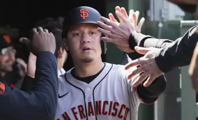 San Francisco Giants' Wilmer Flores celebrates with teammates after scoring on a one-run single by Christian Koss during the fourth inning of a baseball game against the Chicago Cubs in Chicago, Wednesday, May 7, 2025. (AP Photo/Nam Y. Huh)