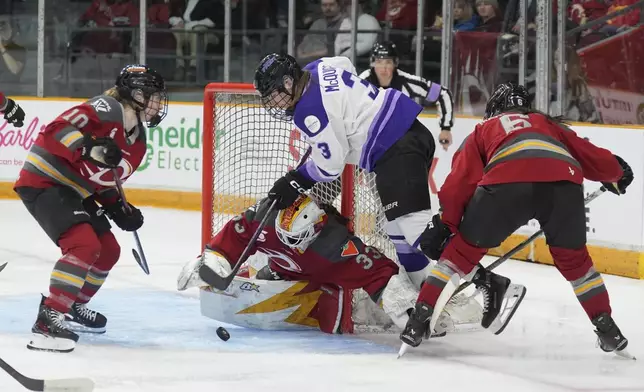 Minnesota Frost forward Brooke McQuigge (3) is stopped by Ottawa Charge goalie Gwyneth Philips (33) under pressure from Ottawa Charge defence Stephanie Markowski (6) and forward Alexa Vasko (10) during the second period of a PWHL game, Wednesday, April 30, 2025 in Ottawa. (Adrian Wyld/The Canadian Press via AP)