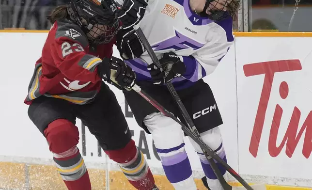 Ottawa Charge defence Jocelyne Larocque (left) pressures Minnesota Frost defence Mellissa Channell-Watkins (23) for control of the puck behind the net during the first period of a PWHL game, Wednesday, April 30, 2025 in Ottawa. (Adrian Wyld/The Canadian Press via AP)