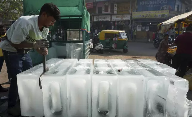FILE - A man arranges ice blocks to sell at his stall in Ahmedabad, India, April 2, 2025. (AP Photo/Ajit Solanki, File)