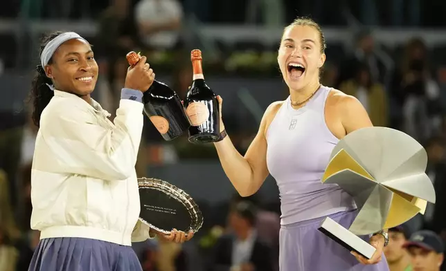 United States' Coco Gauff, left, and the winner Aryna Sabalenka of Belarus stand on the podium after the Madrid Open tennis final in Madrid, Spain, Saturday, May 3, 2025. (AP Photo/Jose Breton)