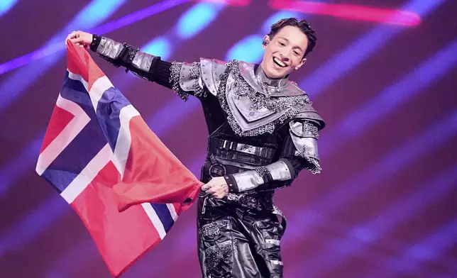 Kyle Alessandro from Norway who will perform the song "Lighter" carries his nations flag onstage during the dress rehearsal for the Grand Final of the 69th Eurovision Song Contest, in Basel, Switzerland, Friday, May 16 2025. (AP Photo/Martin Meissner)