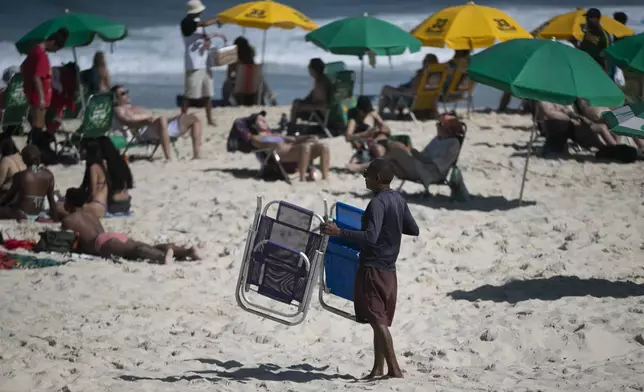 A man shows people chairs for rent on Ipanema Beach in Rio de Janeiro, Sunday, May 25, 2025. (AP Photo/Bruna Prado)