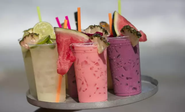 Vendor Leandro Azevedo carries a tray of fruit cocktail to customers on Ipanema Beach in Rio de Janeiro, Sunday, May 25, 2025. (AP Photo/Bruna Prado)