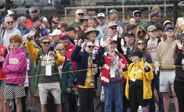 Fans waive during parade laps before the start of the Indianapolis 500 auto race at Indianapolis Motor Speedway in Indianapolis, Sunday, May 25, 2025. (AP Photo/AJ Mast)