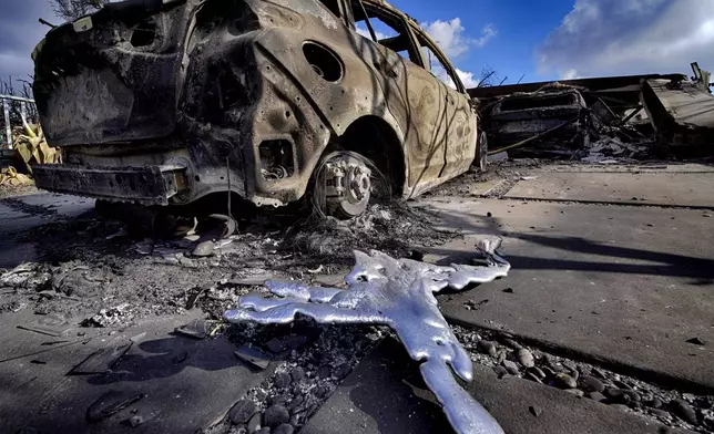 FILE - Melted metal and burned out cars sit destroyed in a driveway of a home burned by the wildfire that spread through the Pacific Palisades neighborhood of Los Angeles on Friday, Jan.17, 2025. (AP Photo/Richard Vogel, File)