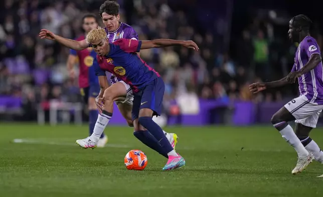 Barcelona's Lamine Yamal, centre, and Valladolid's Antonio Candela, left, challenge for the ball during the Spanish La Liga soccer match between Valladolid and FC Barcelona at the Jose Zorrilla stadium in Valladolid, Spain, Saturday, May 3, 2025. (AP Photo/Manu Fernandez)