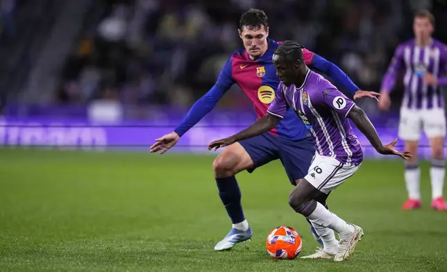 Barcelona's Andreas Christensen, left, and Valladolid's Marcos Andre challenge for the ball during the Spanish La Liga soccer match between Valladolid and FC Barcelona at the Jose Zorrilla stadium in Valladolid, Spain, Saturday, May 3, 2025. (AP Photo/Manu Fernandez)