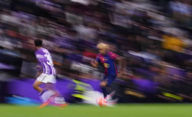 Barcelona's Lamine Yamal, centre, controls the ball during the Spanish La Liga soccer match between Valladolid and FC Barcelona at the Jose Zorrilla stadium in Valladolid, Spain, Saturday, May 3, 2025. (AP Photo/Manu Fernandez)