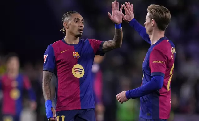 Barcelona's Raphinha, left, and Barcelona's Frenkie de Jong celebrate after the Spanish La Liga soccer match between Valladolid and FC Barcelona at the Jose Zorrilla stadium in Valladolid, Spain, Saturday, May 3, 2025. (AP Photo/Manu Fernandez)