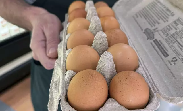 FILE - Joe Trimble, owner of Encinal Market, holds an open carton of eggs in Alameda, Calif., on Tuesday, Feb. 11, 2025. (AP Photo/Terry Chea, File)