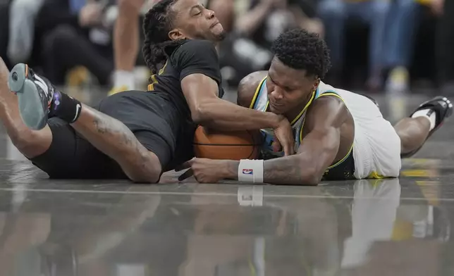 Cleveland Cavaliers guard Darius Garland, left, and Indiana Pacers guard Bennedict Mathurin, right, battle for a loose ball during the second half of Game 3 in the Eastern Conference semifinals of the NBA basketball playoffs in Indianapolis, Friday, May 9, 2025. (AP Photo/Michael Conroy)