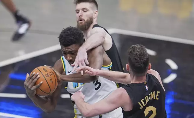 Indiana Pacers center Thomas Bryant (3) battles for the ball with Cleveland Cavaliers forward Dean Wade, top, and guard Ty Jerome (2) during the first half of Game 3 in the Eastern Conference semifinals of the NBA basketball playoffs in Indianapolis, Friday, May 9, 2025. (AP Photo/Michael Conroy)