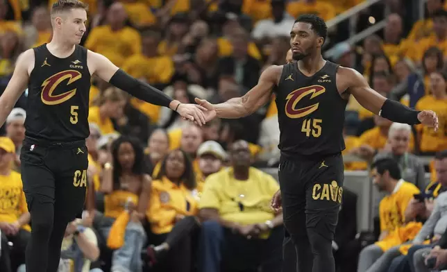 Cleveland Cavaliers guard Sam Merrill (5) and guard Donovan Mitchell (45) celebrate during the second half of Game 3 in the Eastern Conference semifinals of the NBA basketball playoffs against the Indiana Pacers in Indianapolis, Friday, May 9, 2025. (AP Photo/Michael Conroy)