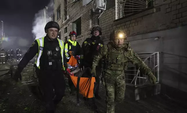 Police carry an injured man on a stretcher after a Russian strike on residential neighborhood in Zaporizhzhia, Ukraine, Thursday, May 1, 2025. (AP Photo/Kateryna Klochko)