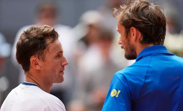 Casper Ruud of Norway, left, shakes hands after winning against Russia's Daniil Medvedev during the Madrid Open tennis tournament in Madrid, Spain, Thursday, May 1, 2025. (AP Photo/Manu Fernandez)