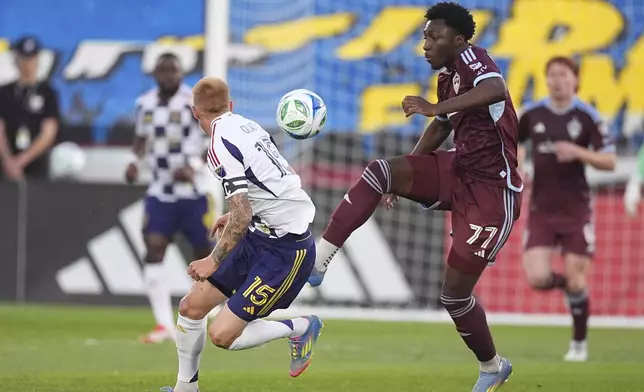 Colorado Rapids forward Darren Yapi, right, passes the ball as Real Salt Lake defender Justen Glad, left, covers in the first half of an MLS soccer match Saturday, May 17, 2025, in Commerce City, Colo. (AP Photo/David Zalubowski)