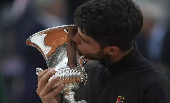 Carlos Alcaraz of Spain, kisses the trophy after winning the Italian Open tennis tournament at the Foro Italico in Rome, Sunday, May 18, 2025. (AP Photo/Alessandra Tarantino)