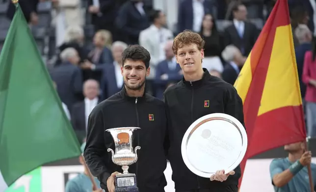 Carlos Alcaraz of Spain, left, and Jannik Sinner of Italy pose for the photographers after their final tennis match in the Italian Open at the Foro Italico in Rome, Sunday, May 18, 2025. (AP Photo/Alessandra Tarantino)