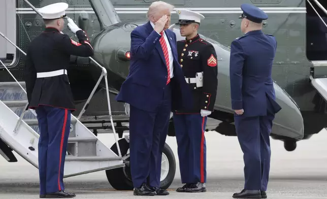 President Donald Trump, center, is greeted by Col. Paul Pawluk, Vice Commander, 89th Airlift Wing, right upon his arrival at Joint Base Andrews, Md., Friday, May 30, 2025. (AP Photo/Luis M. Alvarez)