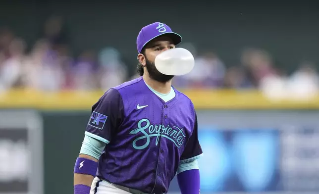 Arizona Diamondbacks third baseman Eugenio Suárez blows a bubble during the first inning of a baseball game against the Colorado Rockies Friday, May 16, 2025, in Phoenix. (AP Photo/Ross D. Franklin)