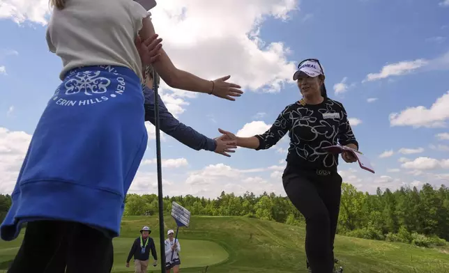 A Lim Kim, of South Korea, greets fans walking to the third tee during the first round of the U.S. Women's Open golf tournament at Erin Hills Thursday, May 29, 2025, in Erin, Wis. (AP Photo/Jeff Roberson)