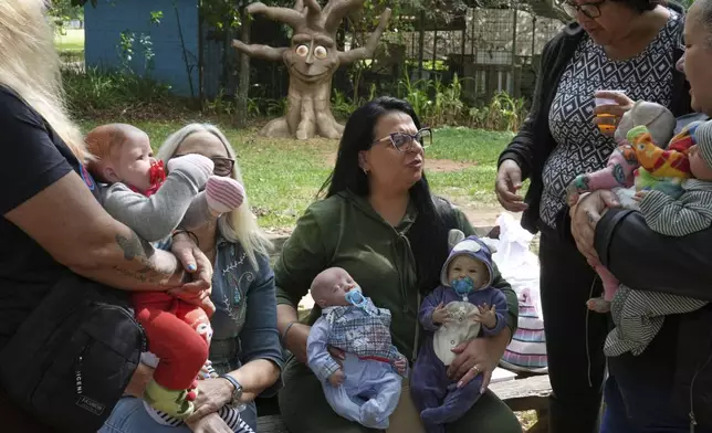A group of women gather in a park to bond and show off their hyper-realistic reborn baby dolls, in Sao Paulo, Saturday, May 24, 2025. (AP Photo/Andre Penner)