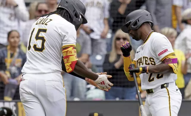 Pittsburgh Pirates' Oneil Cruz, left, is greeted by Andrew McCutchen, right, after hitting a home run during the third inning of a baseball game against the Milwaukee Brewers, Sunday, May 25, 2025, in Pittsburgh. (AP Photo/Matt Freed)