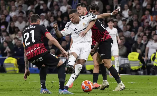 Real Madrid's Kylian Mbappe, centre, scores his side's first goal during a Spanish La Liga soccer match between Real Madrid and Mallorca in Madrid, Spain, Wednesday, May 14, 2025. (AP Photo/Manu Fernandez)