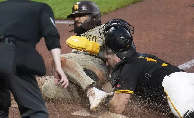 San Diego Padres' Fernando Tatis Jr., left, scores before Pittsburgh Pirates catcher Joey Bart can apply the tag on a wild pitch by pitcher David Bednar during the ninth inning of a baseball game in Pittsburgh, Saturday, May 3, 2025. (AP Photo/Gene J. Puskar)