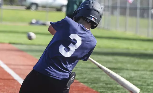Youth ballplayer Josiah Jones bats during youth baseball game in Monroeville, Pa., with his sliding matt in his back pocket on April 27, 2025. (AP Photo/Gene J. Puskar)