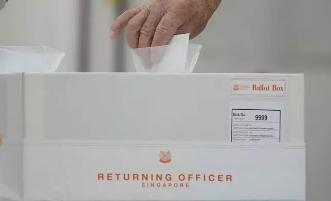 A Singaporean voter casts their vote for general election at polling station in Singapore, Saturday, May 3, 2025. (AP Photo/Vincent Thian)