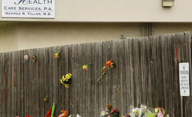FILE - Mementos are placed at a memorial outside Women's Health Care Services owned by Dr. George Tiller in Wichita, Kan., Tuesday, June 2, 2009, after he was fatally shot during church services Sunday. (AP Photo/Charlie Riedel, File)