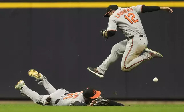 Baltimore Orioles' Cedric Mullins (31) and Ramón Laureano (12) are unable to catch a fly ball during the fifth inning of a baseball game against the Milwaukee Brewers, Monday, May 19, 2025, in Milwaukee. (AP Photo/Aaron Gash)