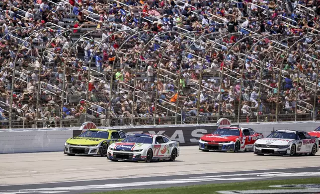 Carson Hocevar (77) and William Byron (24) lead the pack to start a NASCAR Cup Series auto race at Texas Motor Speedway in Fort Worth, Texas, Sunday, May 4, 2025. (AP Photo/Gareth Patterson)
