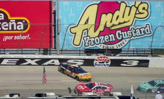 Noah Gragson (4) crashes in Turn 3 as Cody Ware (51) and Michael McDowell (71) pass him during a NASCAR Cup Series auto race at Texas Motor Speedway in Fort Worth, Texas, Sunday, May 4, 2025. (AP Photo/Larry Papke)