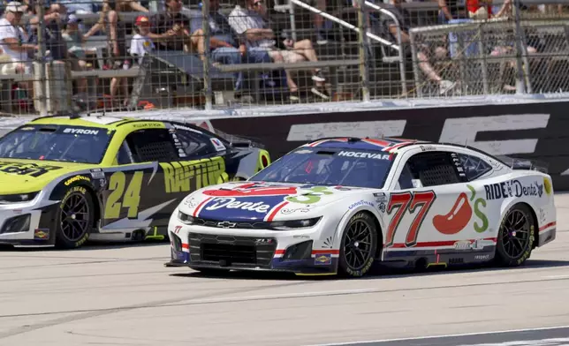 Carson Hocevar (77) and William Byron (24) lead the pack to start a NASCAR Cup Series auto race at Texas Motor Speedway in Fort Worth, Texas, Sunday, May 4, 2025. (AP Photo/Gareth Patterson)
