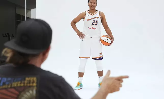Phoenix Mercury forward Alyssa Thomas (25) takes direction from team photographer Barry Gossage during Mercury Media Day at the team's WNBA basketball training facility, Wednesday, April 30, 2025, in Phoenix. (AP Photo/Ross D. Franklin)