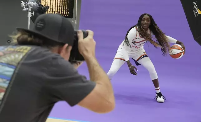 Phoenix Mercury guard-forward Kahleah Copper, right, dribbles the ball in front of team photographer Barry Gossage during a photo shoot at Mercury Media Day at the team's WNBA basketball training facility, Wednesday, April 30, 2025, in Phoenix. (AP Photo/Ross D. Franklin)