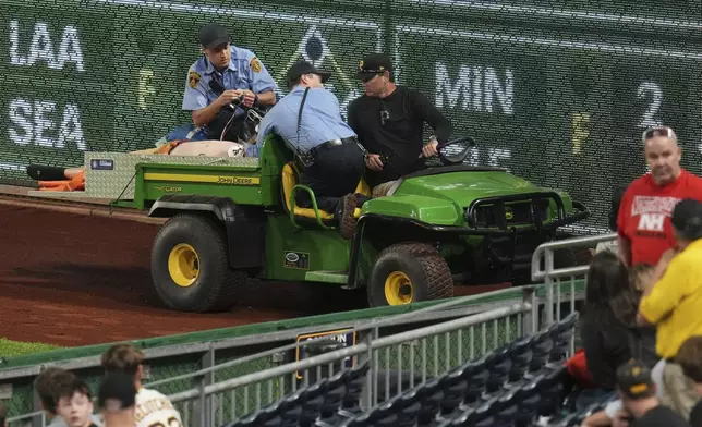 A fan is carted off the field at PNC Park after falling out of the stands during the seventh inning of a baseball game between the Pittsburgh Pirates and the Chicago Cubs in Pittsburgh, Wednesday, April 30, 2025. (AP Photo/Gene J. Puskar)
