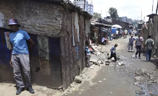 Residents walk through a small and crowded market in the Mathare informal settlement of the capital Nairobi, Kenya Saturday, April 5, 2025. (AP Photo/Andrew Kasuku)