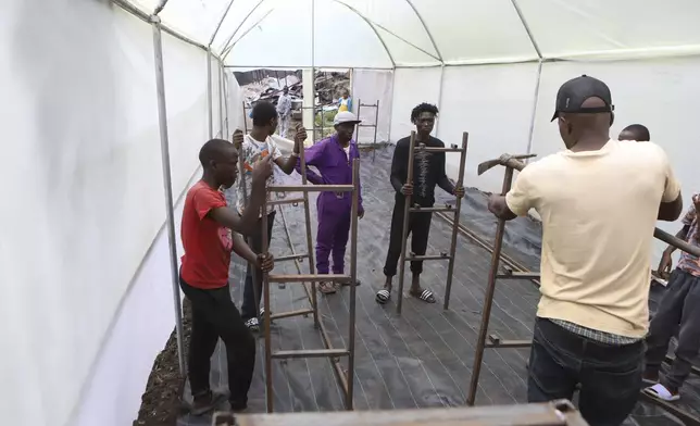 Reformed gangsters and members of Vision Bearerz Youth Group construct a greenhouse in the Mathare informal settlement of the capital Nairobi, Kenya Saturday, April 5, 2025. (AP Photo/Andrew Kasuku)