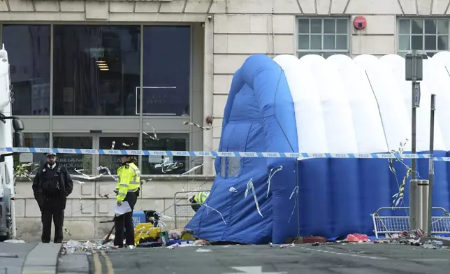 Police officers examine the road after a car collided with pedestrians near the Liver Building during yesterday's Premier League winners parade in Liverpool, England, Tuesday, May 27, 2025.(AP Photo/Jon Super)