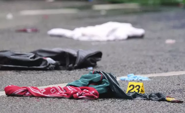 Evidence is marked near the site where a 53-year-old British man plowed a minivan into a crowd of Liverpool soccer fans who were celebrating the city's Premier League championship Monday, injuring more than 45 people in Liverpool, England, Tuesday, May 27, 2025.(AP Photo/Jon Super)