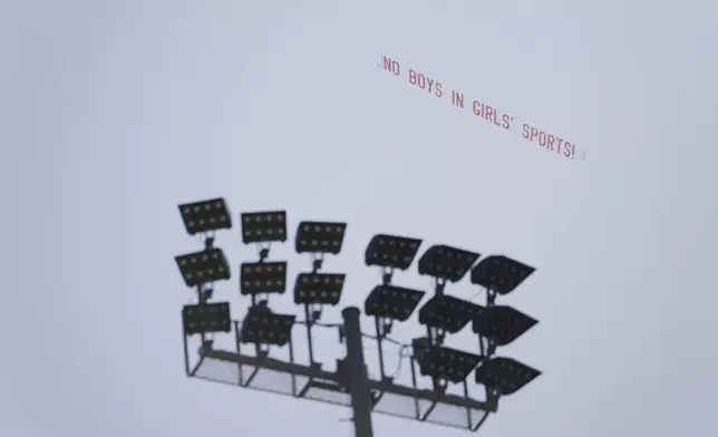 A banner reading "NO BOYS IN GIRLS' SPORTS!" is flown above Veteran's Memorial Stadium during the California high school track-and-field championships in Clovis, Calif., Friday, May 30, 2025. (AP Photo/Jae C. Hong)