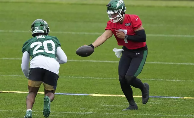 New York Jets quarterback Justin Fields (7) hands off to Breece Hall during an NFL football practice in Florham Park, N.J., Thursday, May 29, 2025. (AP Photo/Seth Wenig)